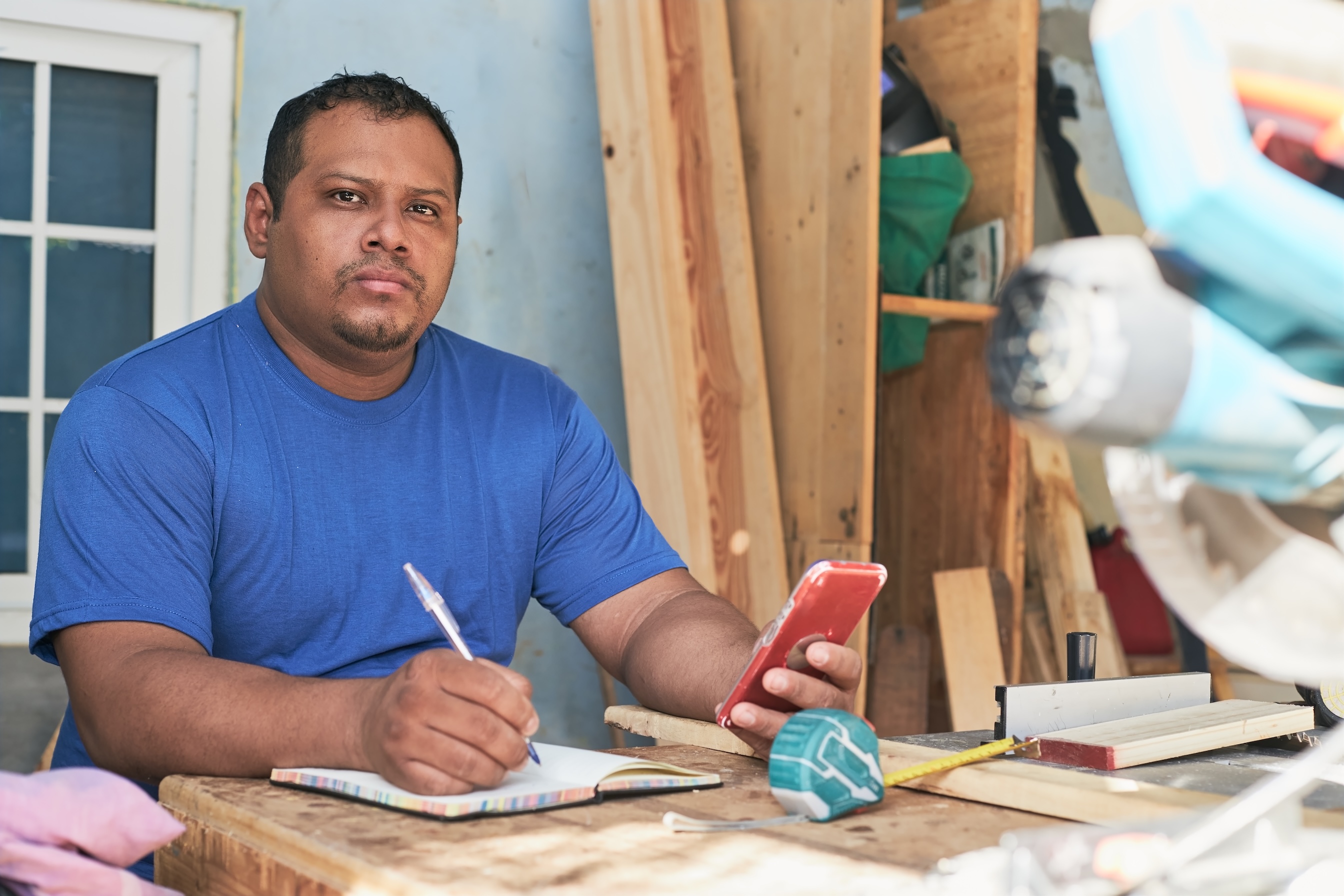 latino man taking notes of the order, in the cabinetry workshop